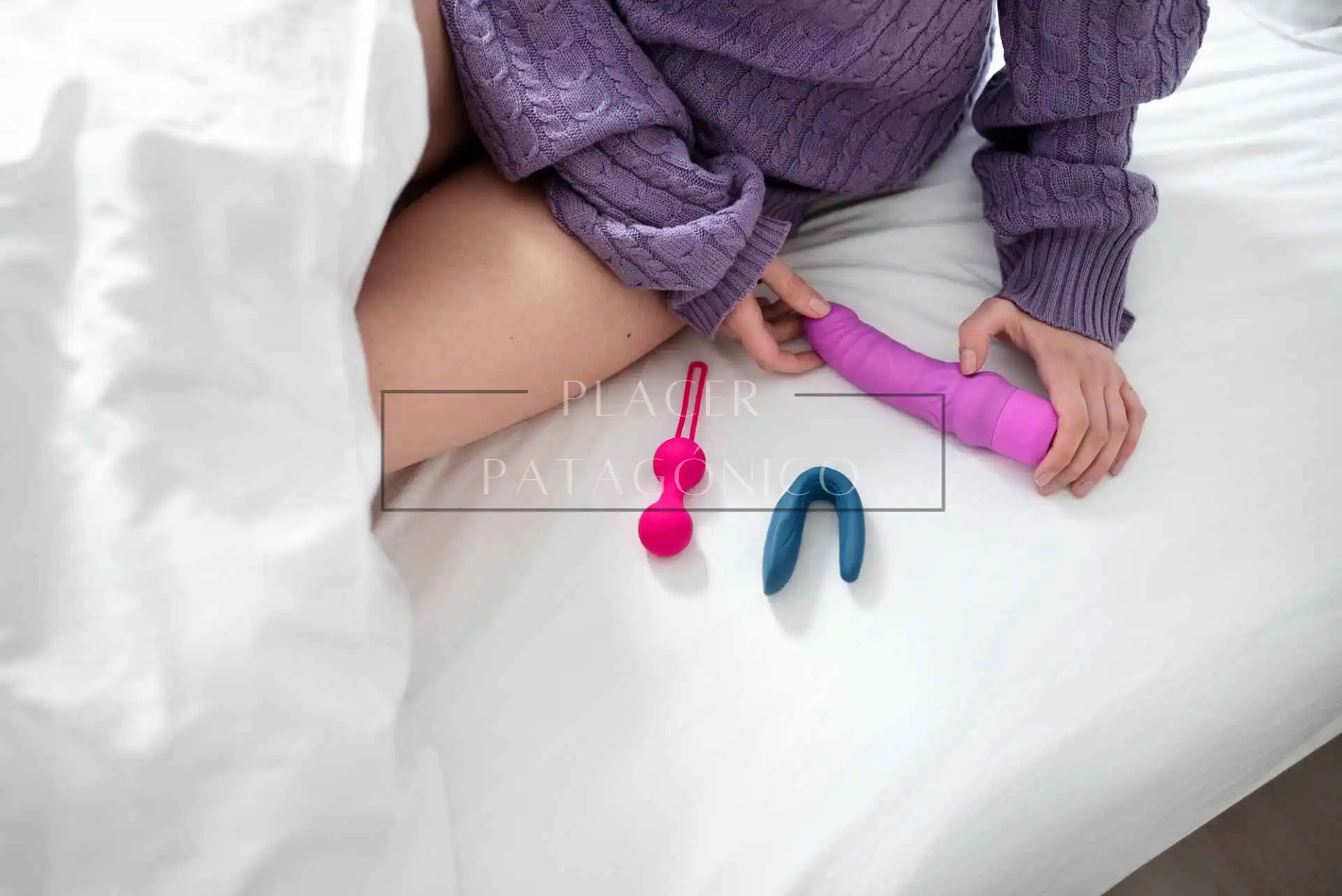 Mujer sentada en la cama sosteniendo un juguete sexual