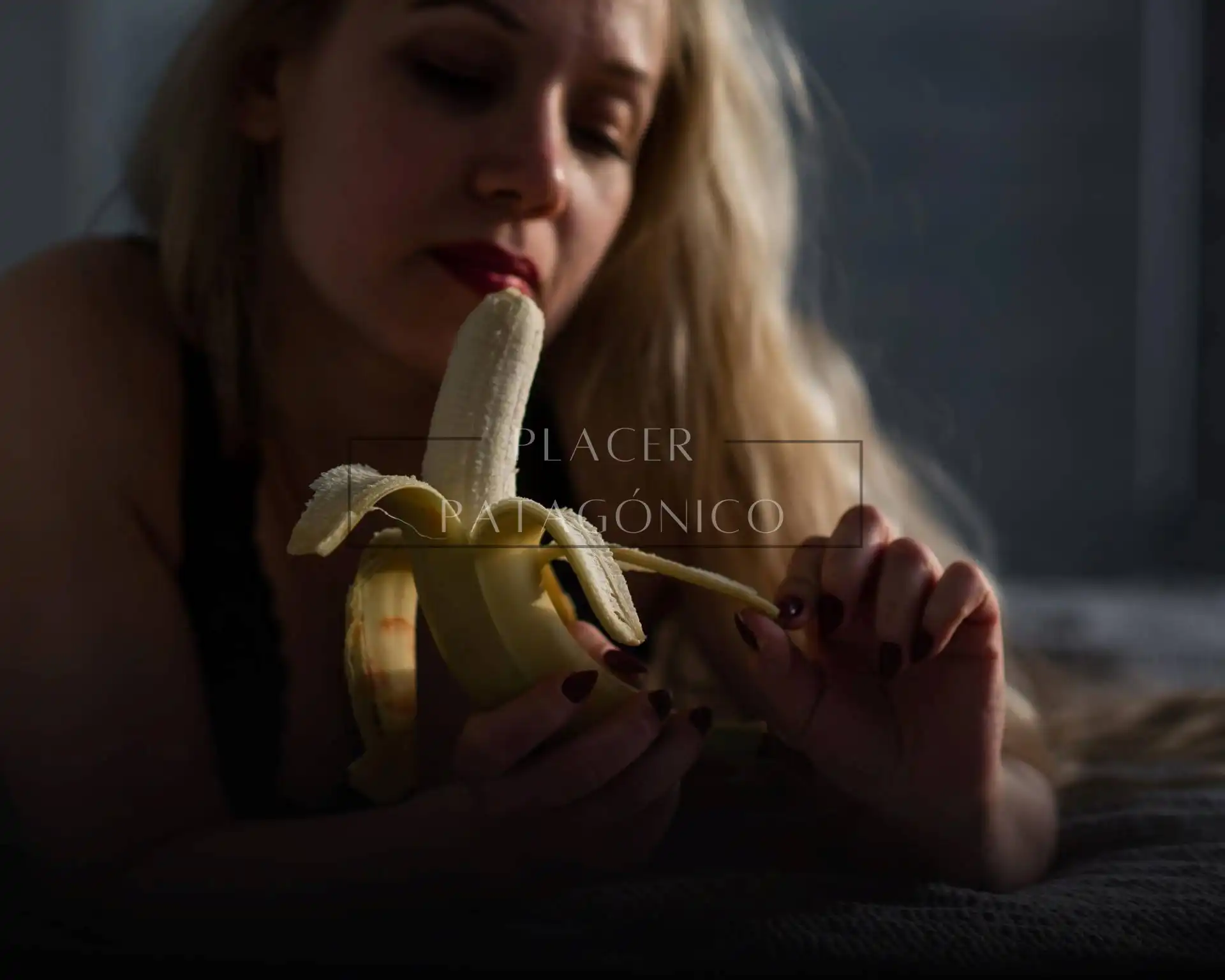 Mujer sensual manipulando una fruta como si fuese pene
