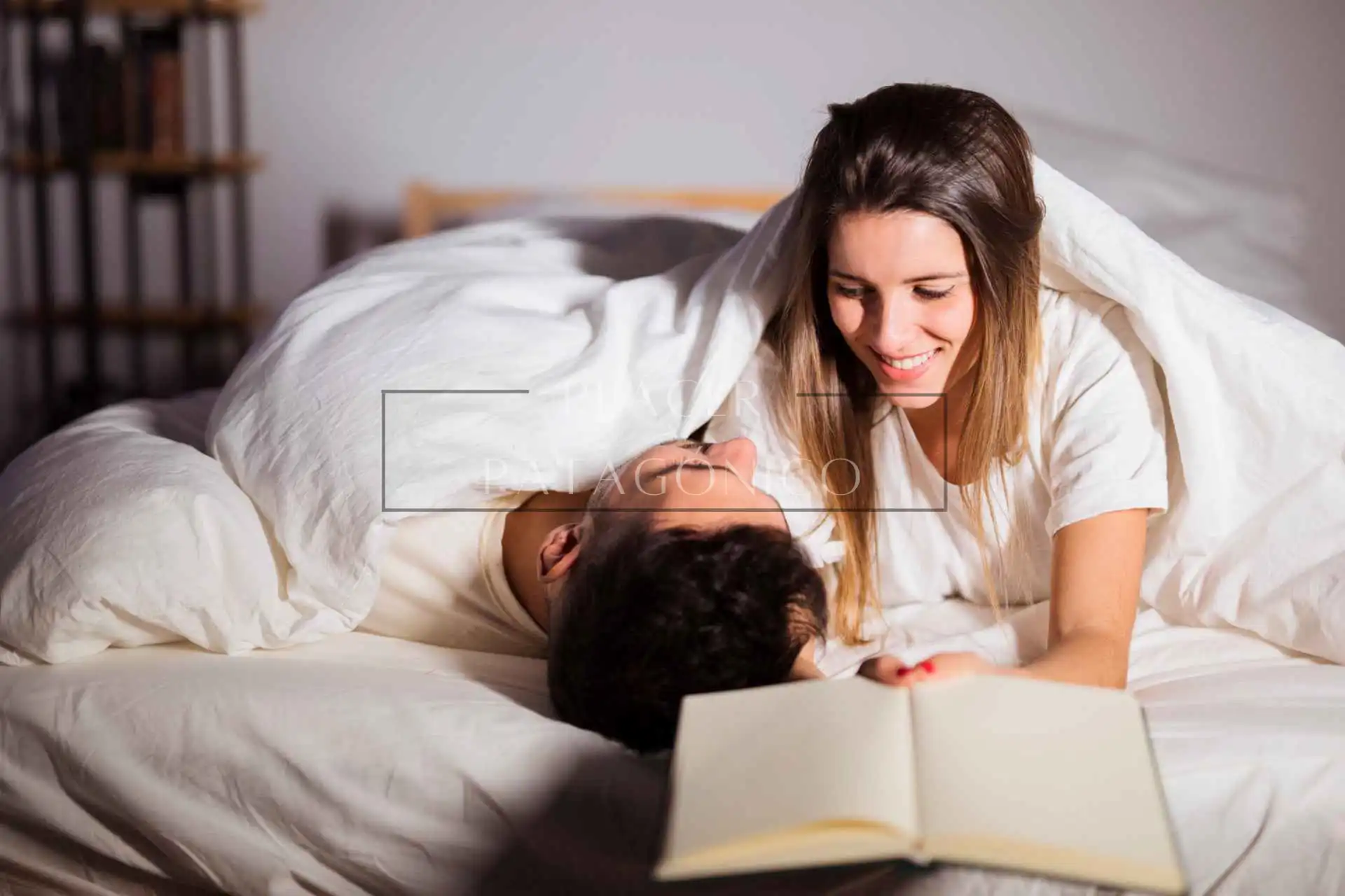 Novios leyendo historias eróticas recostados en la cama